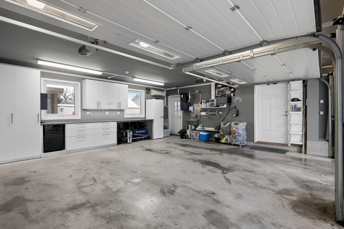 Garage with stained, bare concrete floor before coating